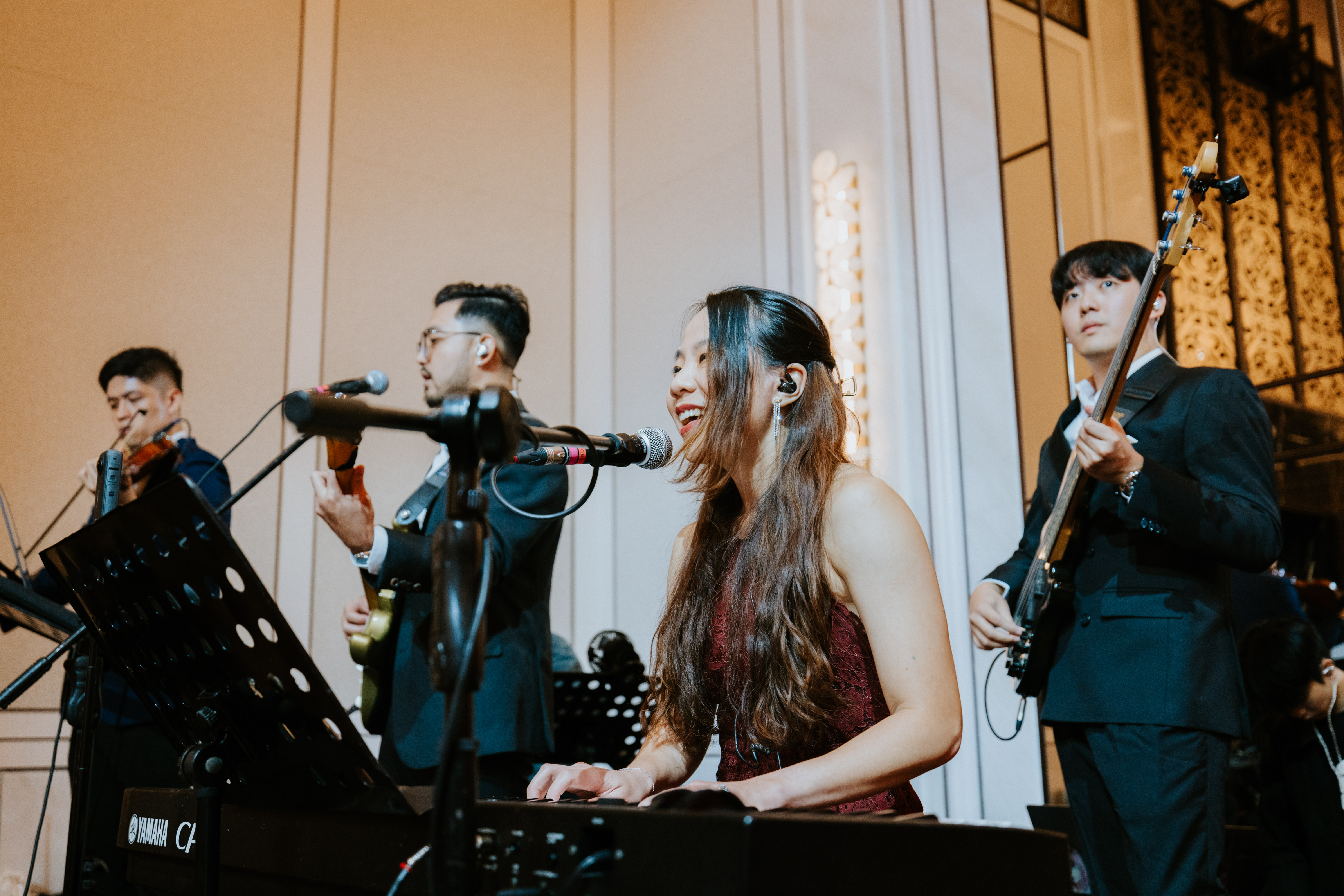 Vocalist mid-set, smiling at the keys